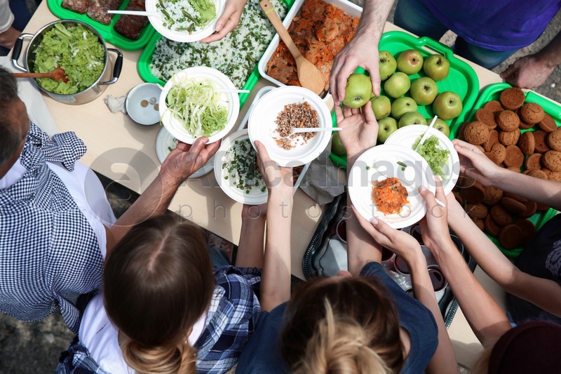 Volunteers serving food for poor people outdoors, top view