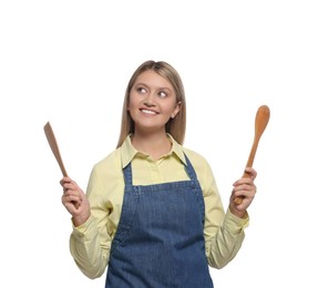 Beautiful young woman in denim apron with cooking utensils on white background