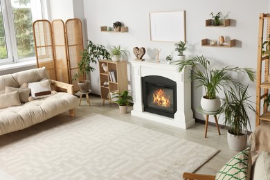 Photo of Stylish living room interior with fireplace, houseplants and beige sofa, flat lay