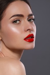 Photo of Young woman with red lips makeup on grey background
