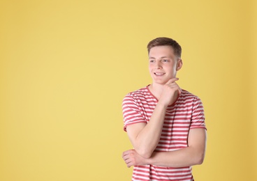 Portrait of teenage boy on yellow background. Space for text
