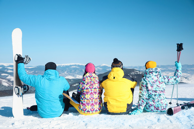 Group of friends with equipment at ski resort, back view. Winter vacation