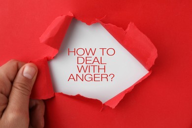 Photo of Woman tearing red paper to reveal inscription How To Deal With Anger? on white background, top view