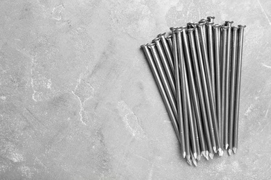 Photo of Many metal nails on grey background, flat lay. Space for text