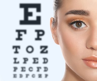 Young woman and blurred eye chart on background. Visiting ophthalmologist 
