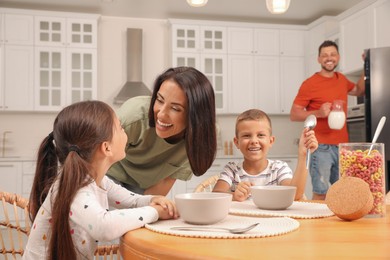 Happy family with children having fun during breakfast at home