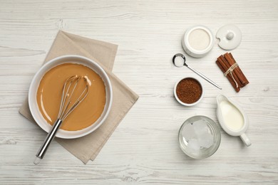 Photo of Whipping cream for dalgona coffee and ingredients on white wooden table, flat lay