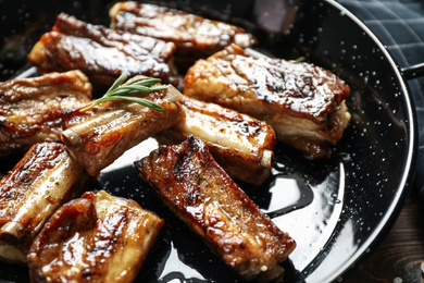 Photo of Delicious grilled ribs with rosemary on table, closeup