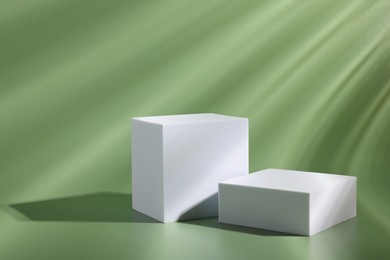 Photo of Scene for product presentation. Podiums of different geometric shapes on pale light green background