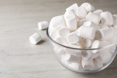 Delicious puffy marshmallows on wooden table, closeup. Space for text