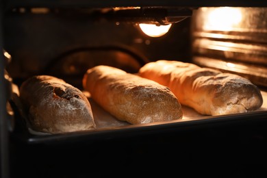 Photo of Cooking tasty fresh crispy ciabattas in oven