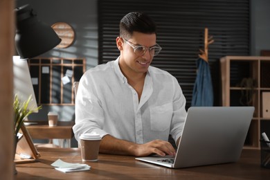 Freelancer working on laptop at table indoors