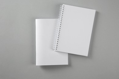 Blank brochure and notebook on grey background, flat lay. Mockup for design