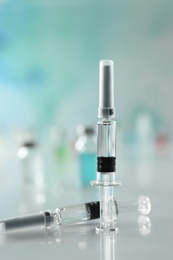 Syringes with COVID-19 vaccine on white table