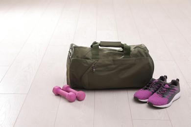 Sports bag and gym equipment on white floor