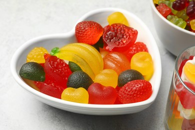 Delicious fruity gummy candies on light grey table, closeup