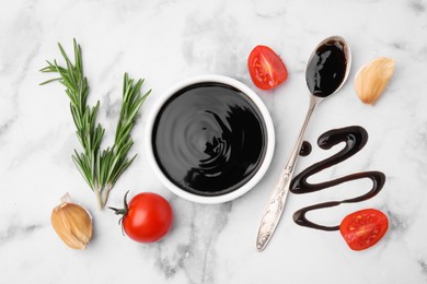 Photo of Organic balsamic vinegar and cooking ingredients on white marble table, flat lay