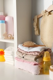 Baby clothes, toy and accessories on white rack