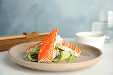 Fresh crab sticks with cucumber served on white table