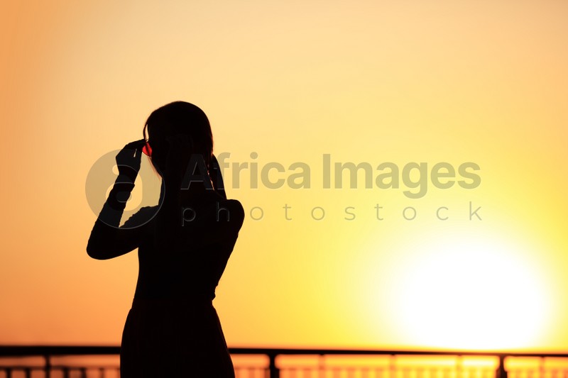 Silhouette of young woman outdoors at sunset