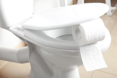 New paper roll on toilet seat in bathroom
