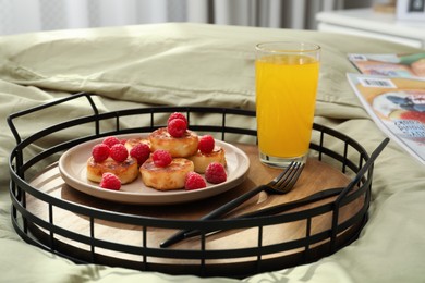 Tasty breakfast served in bedroom. Cottage cheese pancakes with fresh raspberries and juice on tray