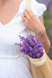 Woman with bag of beautiful lavender flowers outdoors, closeup