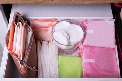 Open cabinet drawer with different menstrual pads, above view