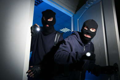 Thieves with flashlights breaking into house at night
