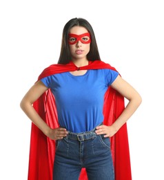 Confident young woman wearing superhero cape and mask on white background