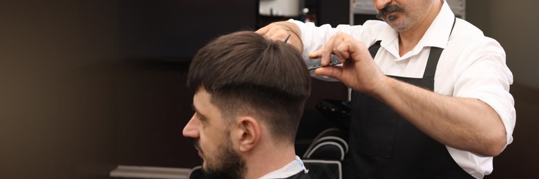 Professional hairdresser cutting man's hair in barbershop. Banner design