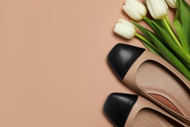 Photo of Pair of new stylish square toe ballet flats and beautiful tulips on beige background, flat lay. Space for text
