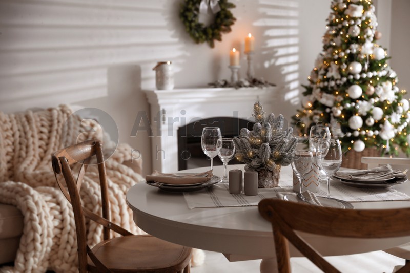 Festive table setting and beautiful Christmas decor in living room. Interior design