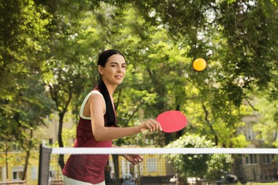 Young woman playing ping pong in park
