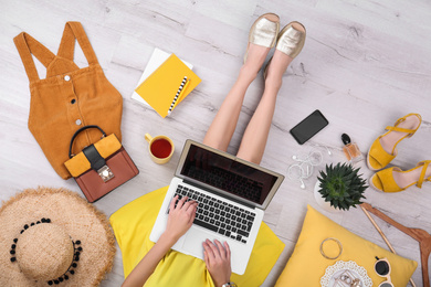 Fashion blogger with laptop sitting on floor, top view