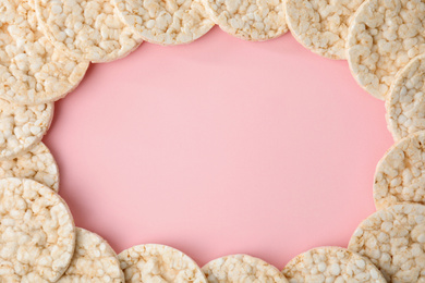Frame made of puffed rice cakes on pink background, flat lay. Space for text