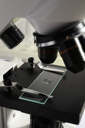 Photo of Microscope with drop of urine on glass slide in laboratory, closeup