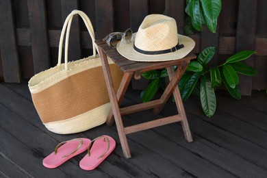 Different stylish beach accessories near wooden fence