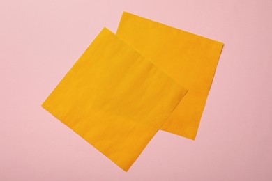 Orange reusable beeswax food wraps on pink background, top view