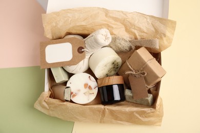Box with eco friendly personal care products on color background, top view
