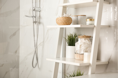 Photo of Shelving unit with toiletries in bathroom interior