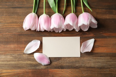 Tulips and greeting card for Mother's Day on wooden background
