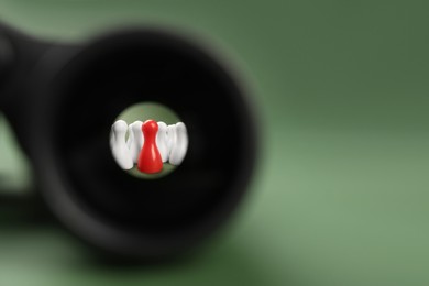 Photo of Recruiter searching employee. Red and white pawns visible through binoculars on green background. Space for text