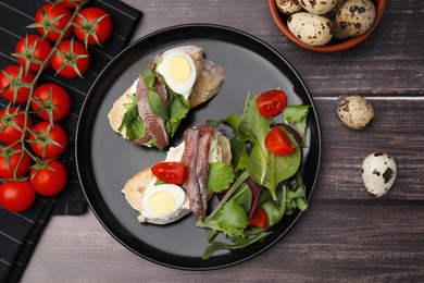 Photo of Delicious bruschettas with anchovies, cream cheese, eggs and tomatoes on wooden table, flat lay