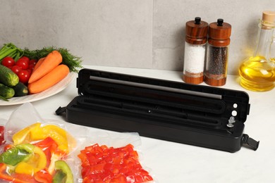 Sealer for vacuum packing and different products on white table indoors