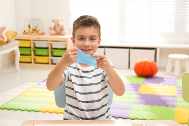 Photo of Little boy playing with slime in room