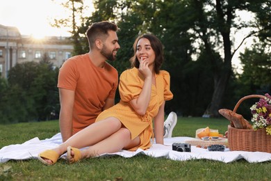 Lovely couple having picnic in park on sunny day