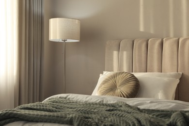Stylish floor lamp near bed in room. Interior element