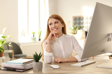 Young woman relaxing at table in office during break