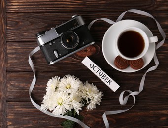 Photo of Flat lay composition with beautiful white chrysanthemum flowers and vintage camera on wooden table